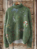 Green sweater with nature-themed embroidery on a wooden background